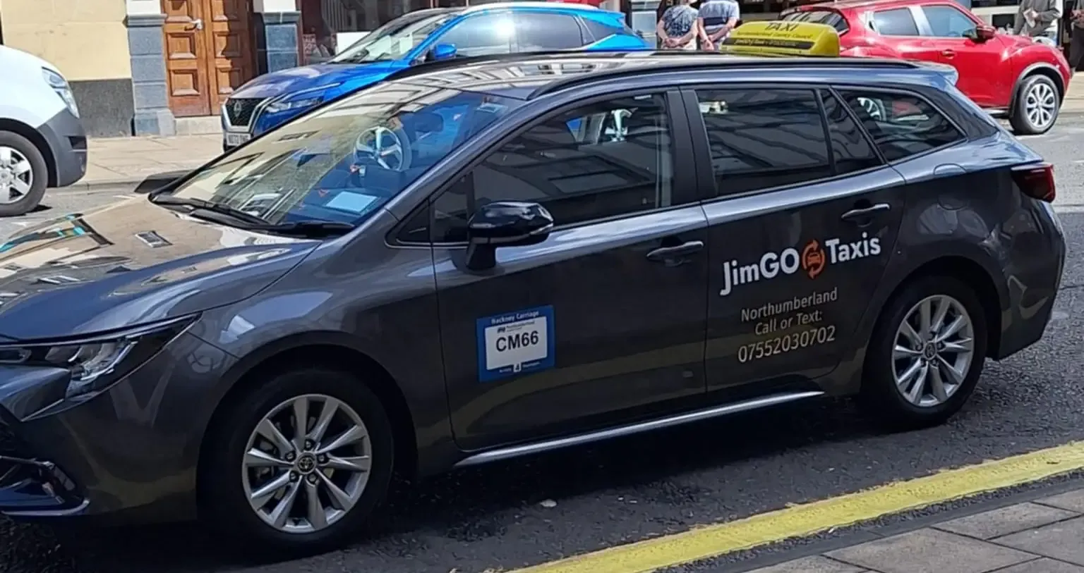 The JimGO taxi parked at the kerb on a Northumberland town street